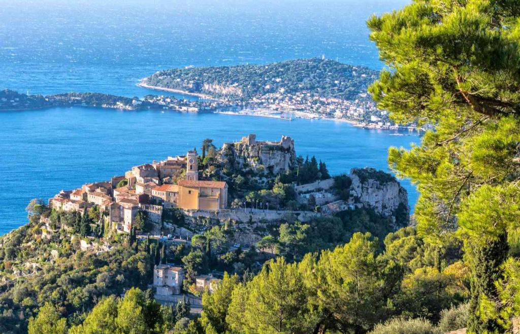 A picture of old town Eze with the castle on top and background of the ocean and Saint-Jean-Cap-Ferrat