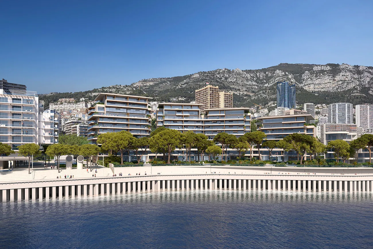 A photo of the Jardins d'Eau Residence residence and Promenade Price Jacques in Monaco. You see the residence, walkway, trees, and the ocean