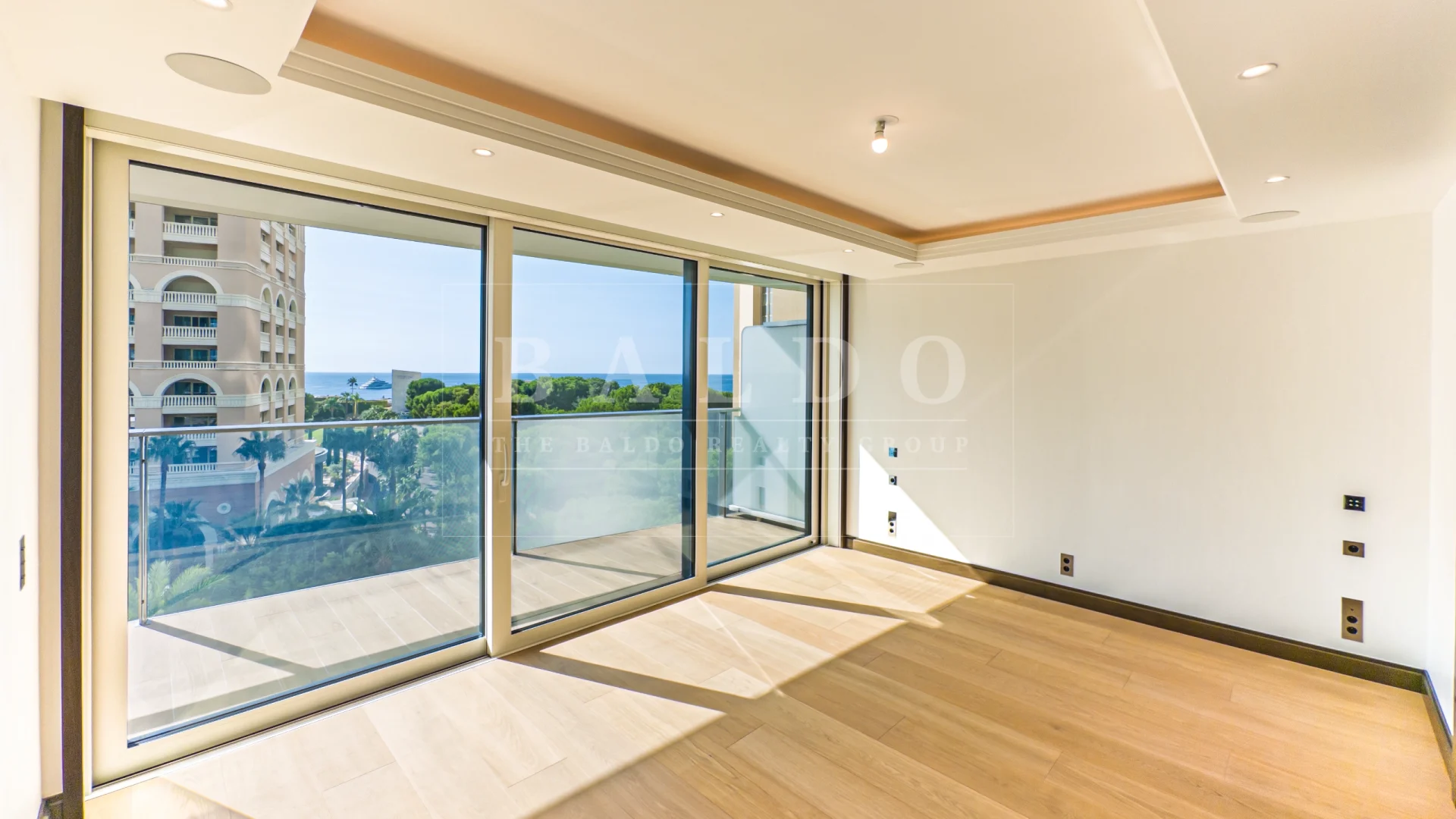 A photo of a bedroom in the Bay House residence in Monaco. In the photo you see the bedroom, closet and view of the Mediterranean.