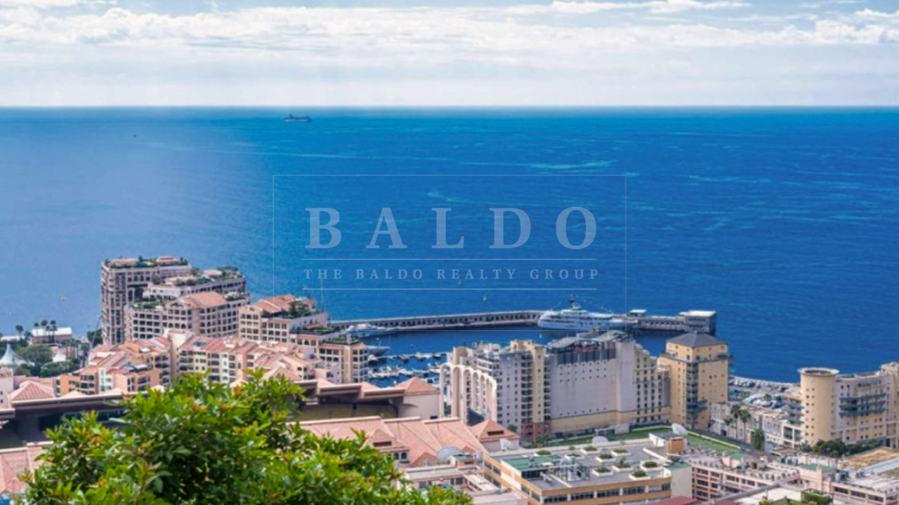 A view of the Mediterranean from the Exotique residence in the Jardin Exotique neighborhood in Monaco. In this photo you see an elevated view of the ocean and fontvieille Monaco. There is a view of Stade Louis II, Seaside Plaza, and the Port of Cap d'Ail.