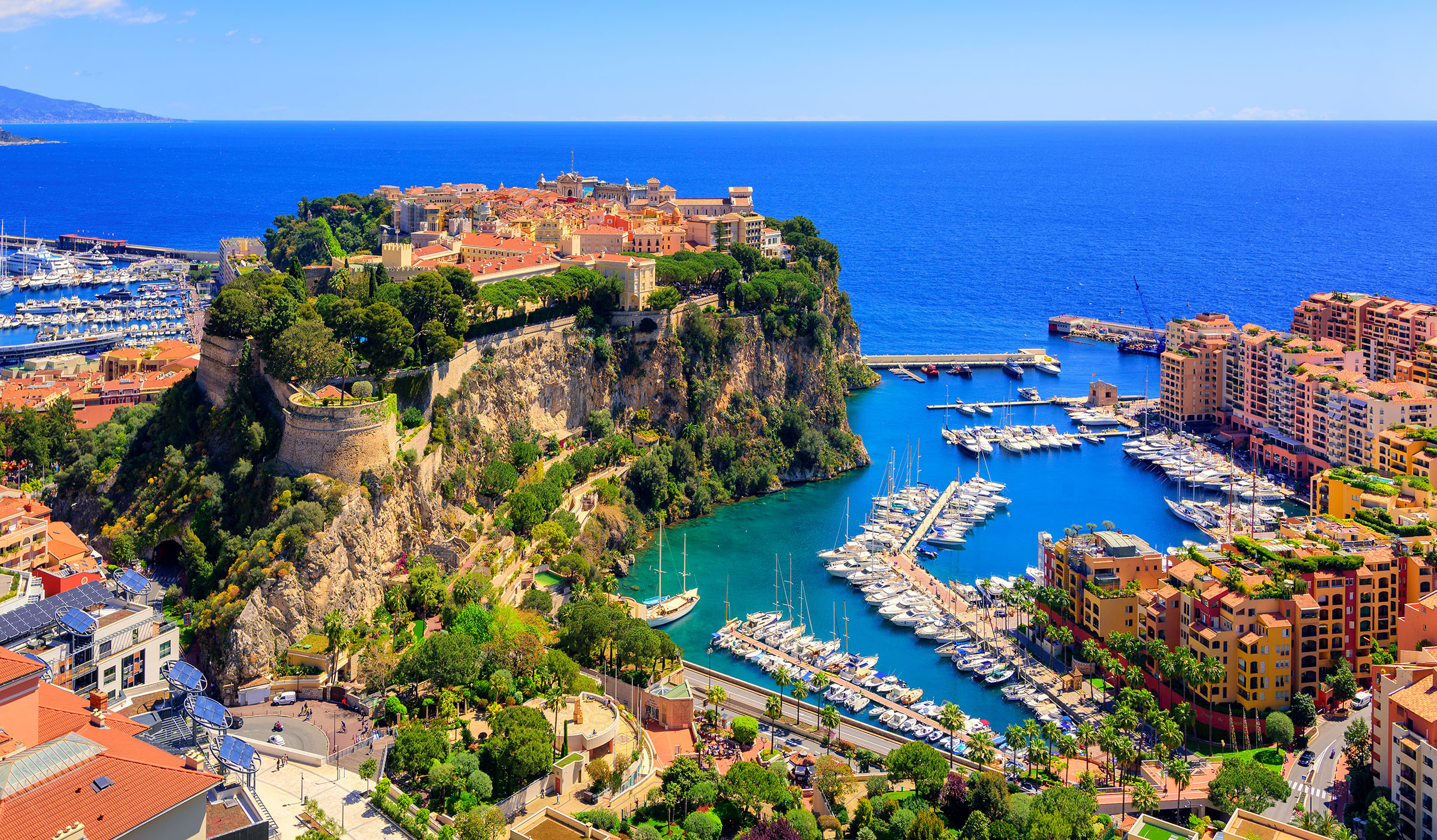 An aerial photo of Le Rocher in Monaco. It has a photo of the old town, port Hercule Palace, and Fontvieille