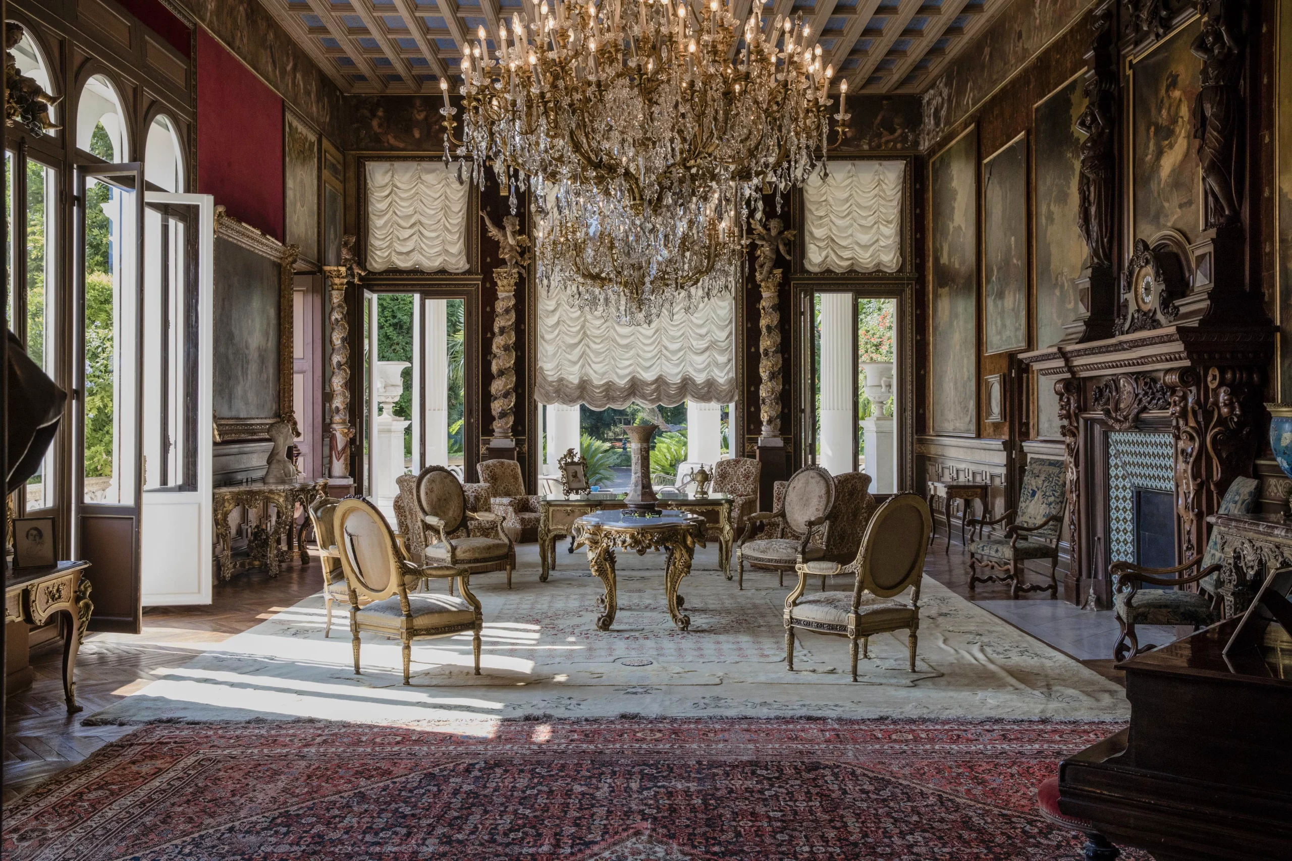 Grand salon inside Villa Les Cèdres with chandeliers and 19th-century portraits
